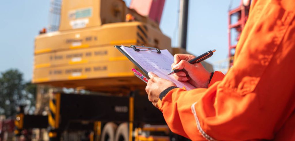 A manager checking and monitoring equipment and workers closely to ensure the site stays productive and safe.