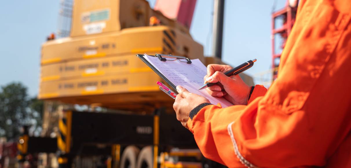 A manager checking and monitoring equipment and workers closely to ensure the site stays productive and safe.