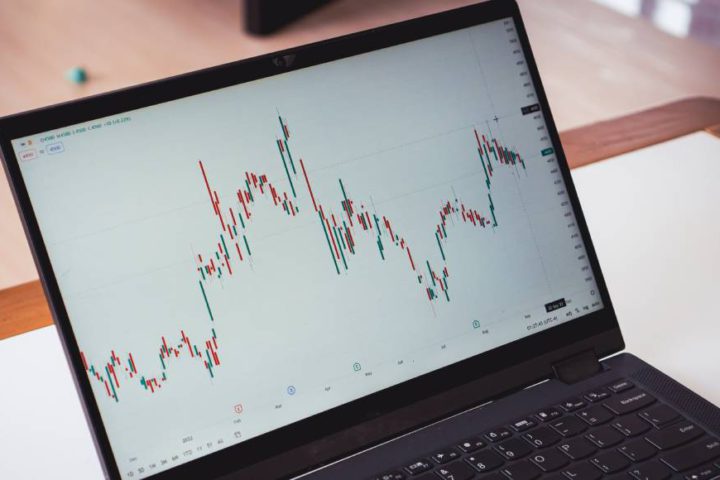 A laptop screen shows a company’s stock price, which is currently unpredictable and indicative of the larger economy.